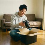 段ボールからカメラを出して喜んでいる人